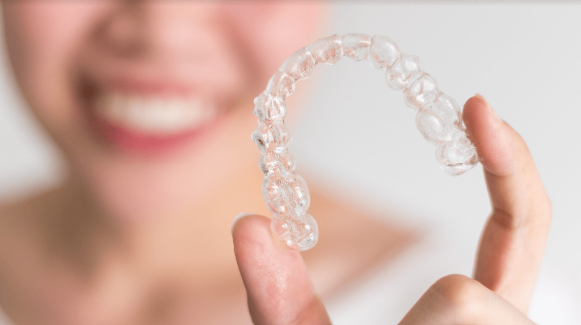 A smiling woman showing her Invisalign clear aligners