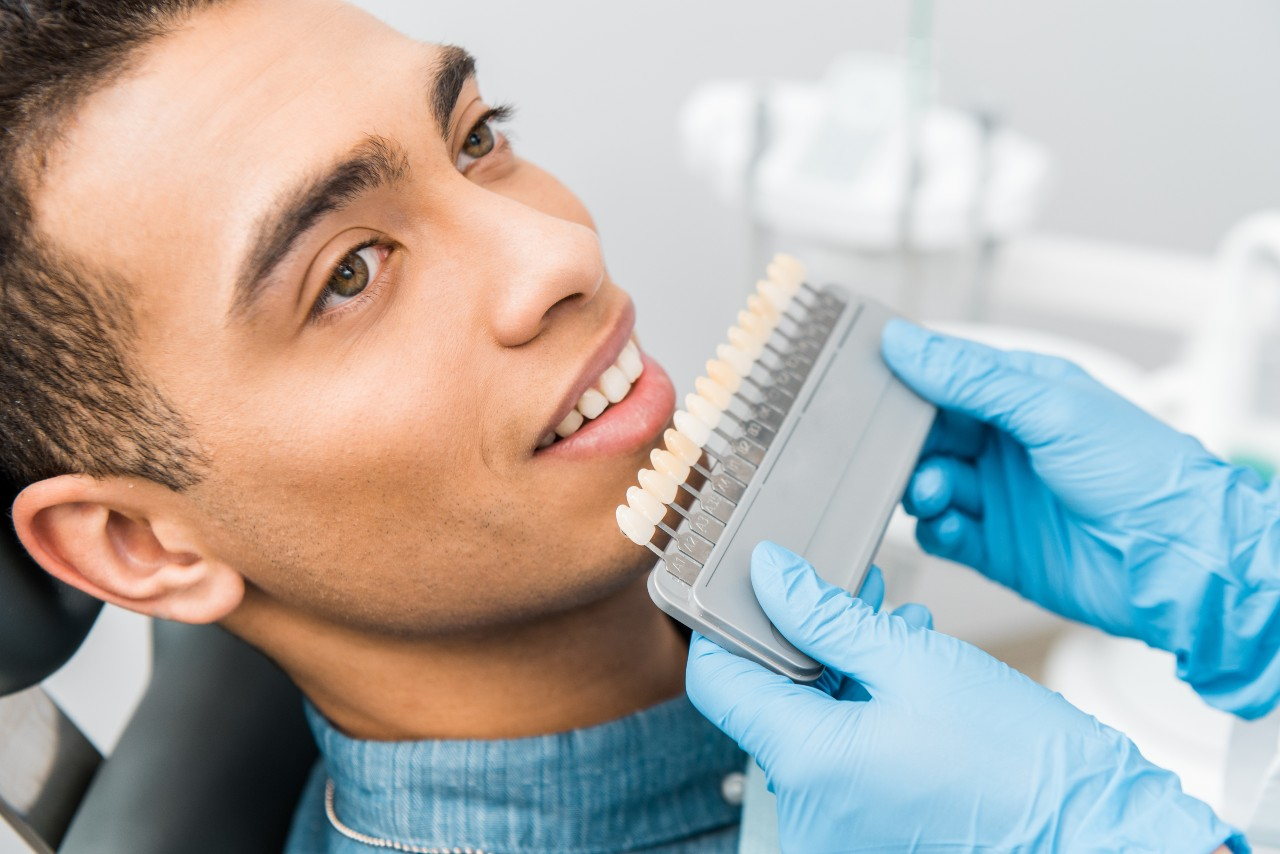 A man receives dental cosmetic treatment at Smile Cafe for teeth whitening.