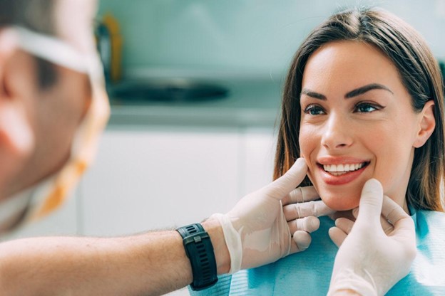    A Dentist Evaluating the Oral Condition of a Patient at Her Full
  Mount Dental Implants Cost Consultation