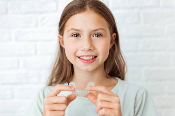  A young girl getting ready to put her Invisalign for Kids into her mouth