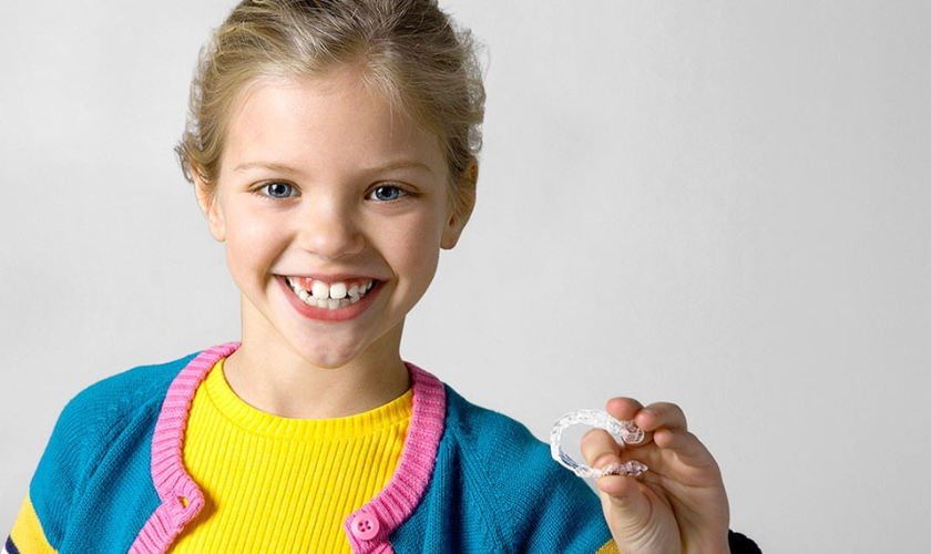  A young girl showing how flexible her Invisalign for Kids aligners are