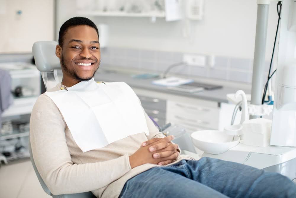   A happy, smiling patient lying on a dental chair at the dentist's office waiting for his IV ozone therapy (intravenous ozone therapy) near him