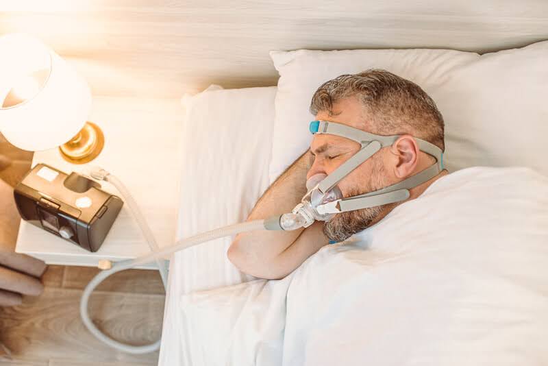 A Man Using a Sleep Apnea Treatment Machine
A Man Using a Sleep Apnea Treatment Machine