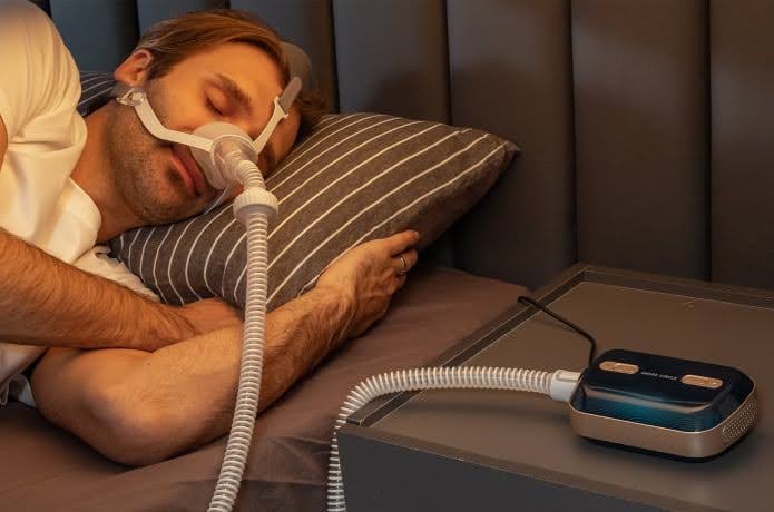 : A Man Sleeping Using A Sleep Apnea Machine