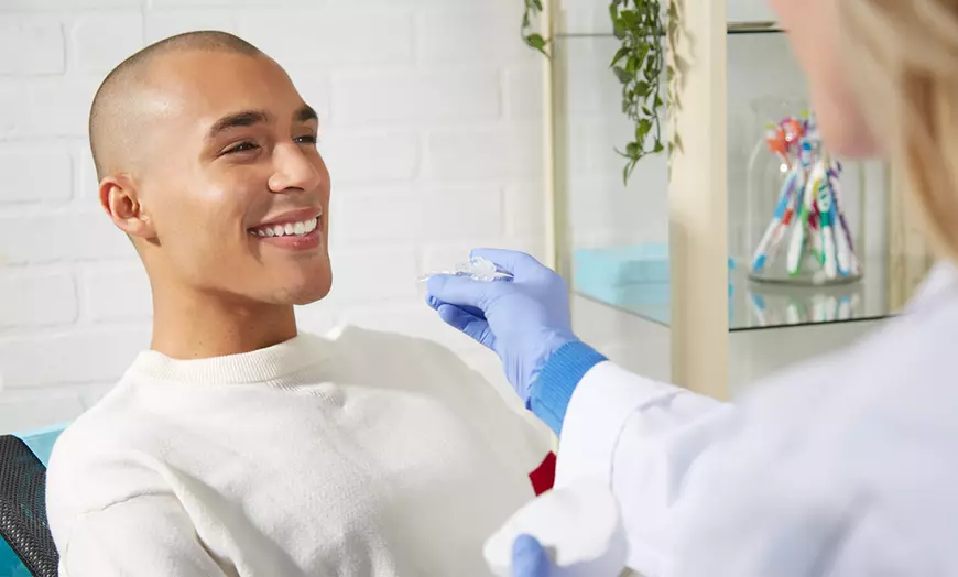 A Patient Smiling at His Biological Dentist While She Is Performing a Functional Dentistry Procedure