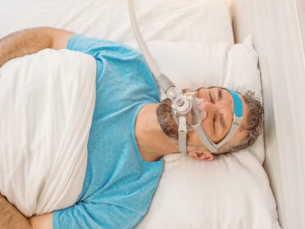 A Man Lying Peacefully in The Bed and Using A Sleep Apnea Machine