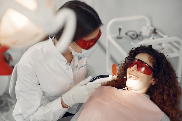  A Dentist Treating Her Patient with the Laser Nightlase Therapy