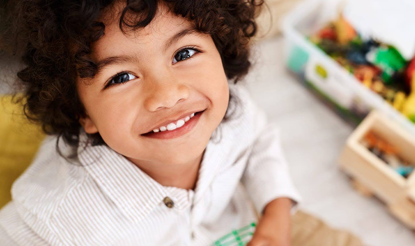 A young child smiling in a toy room